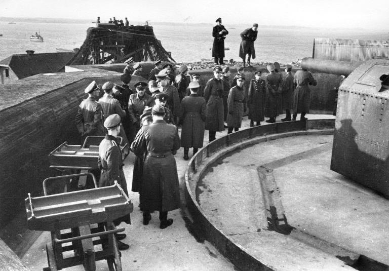 Vue d'une inspection des travaux de fortification de l'île Cézembre en présence d'une délégation japonaise : armement d'un canon de 19,4 cm, fin 1942-1943. En arrière-plan : un télémètre. Il s'agit d'une photographie de propagande nazie