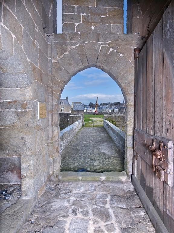 Vue intérieure de la tour Solidor : rez-de-chaussée, passage d'entrée avec porte en tiers-point débouchant vers l'est. Au-dessus de la porte se trouvent les rainures des flèches du pont-levis