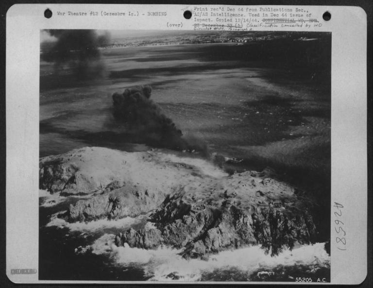 Vue de l'Île Cézembre sous les bombardements américains : fumées après l'explosion de bombes incendiaires au napalm, 31 août 1944. L'île est constellée de cratères