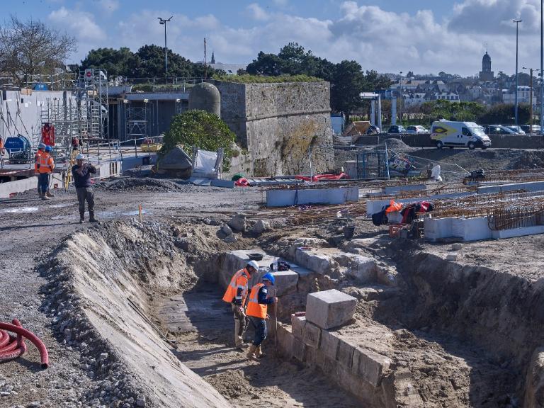Vue de l'opération archéologique réalisée sous la responsabilité de Ronan Louessard - INRAP avec un suivi scientifique et technique du DRASSM (couverture photographique du 11 mars 2026). En arrière-plan, le fort du Naye