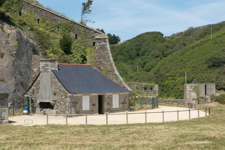 Vue du corps de garde de la batterie basse du Mengant (état en 2009). En arrière-plan, la branche tombante est et l'entrée de la batterie basse flanquée d'un bunker-poste d'observation et de tir
