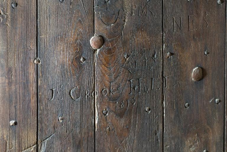 Vue intérieure de la tour Solidor : détail des graffitis de la porte du premier étage. On peut lire : J Crooks HuLC 1810 ; PMR ; NES et identifier un brick (voilier à deux mâts)