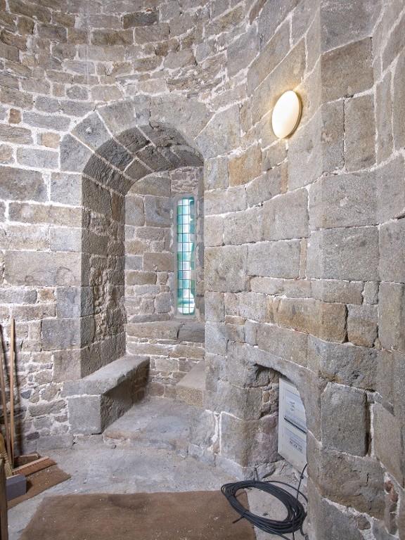 Vue intérieure de la tour Solidor : rez-de-chaussée, tour nord, arbalétrière-canonnière à double coussiège orientée vers l'est et cheminée (abritant le tableau électrique)